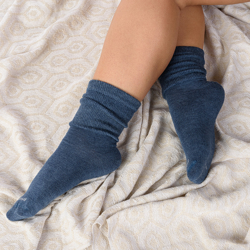 A person lounging on a blanket wearing Extra Easy Relaxed Fit/Diabetic Friendly socks.
